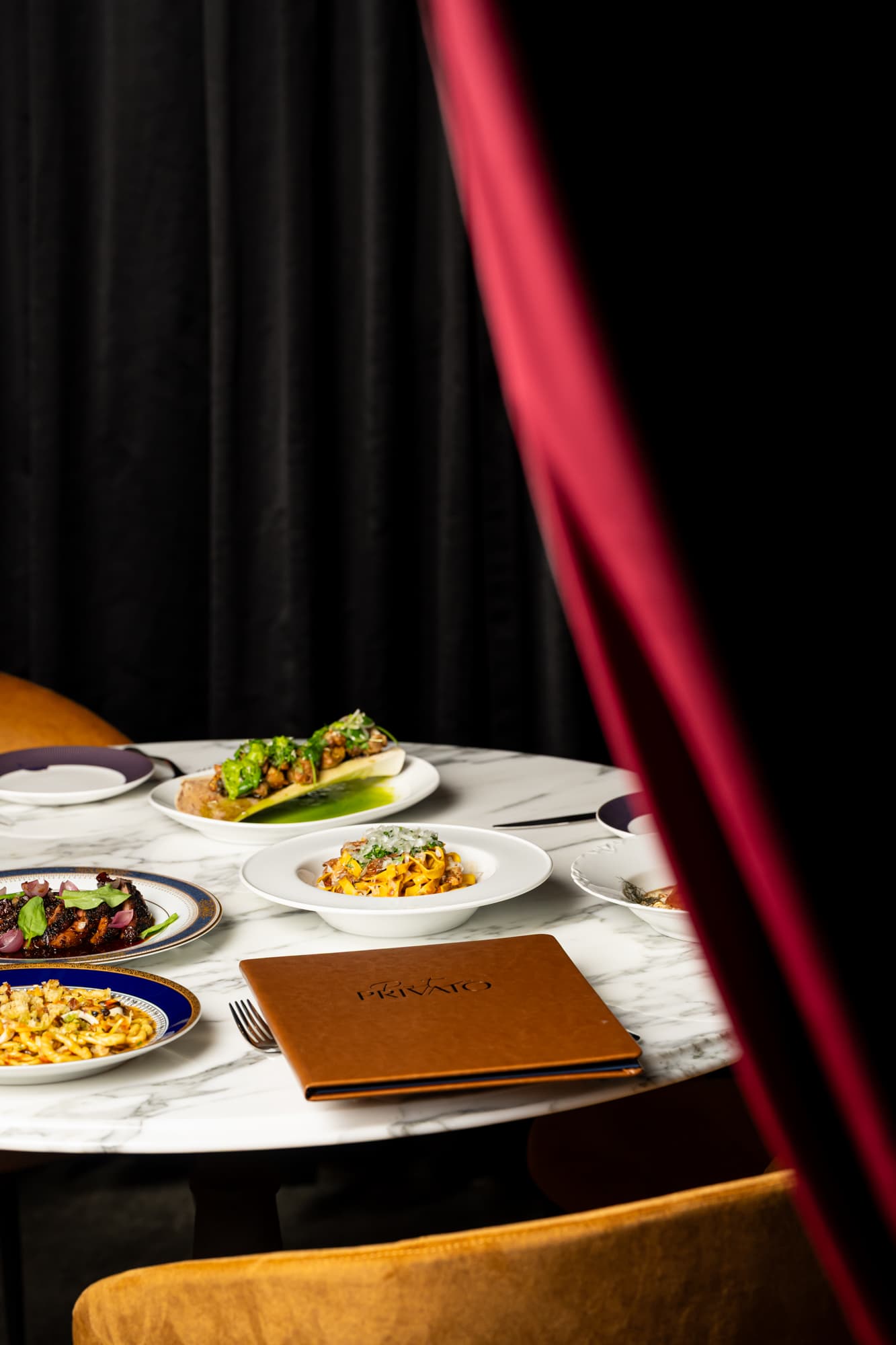 A Pastalicious table set behind Pasta Privato's velvet curtain