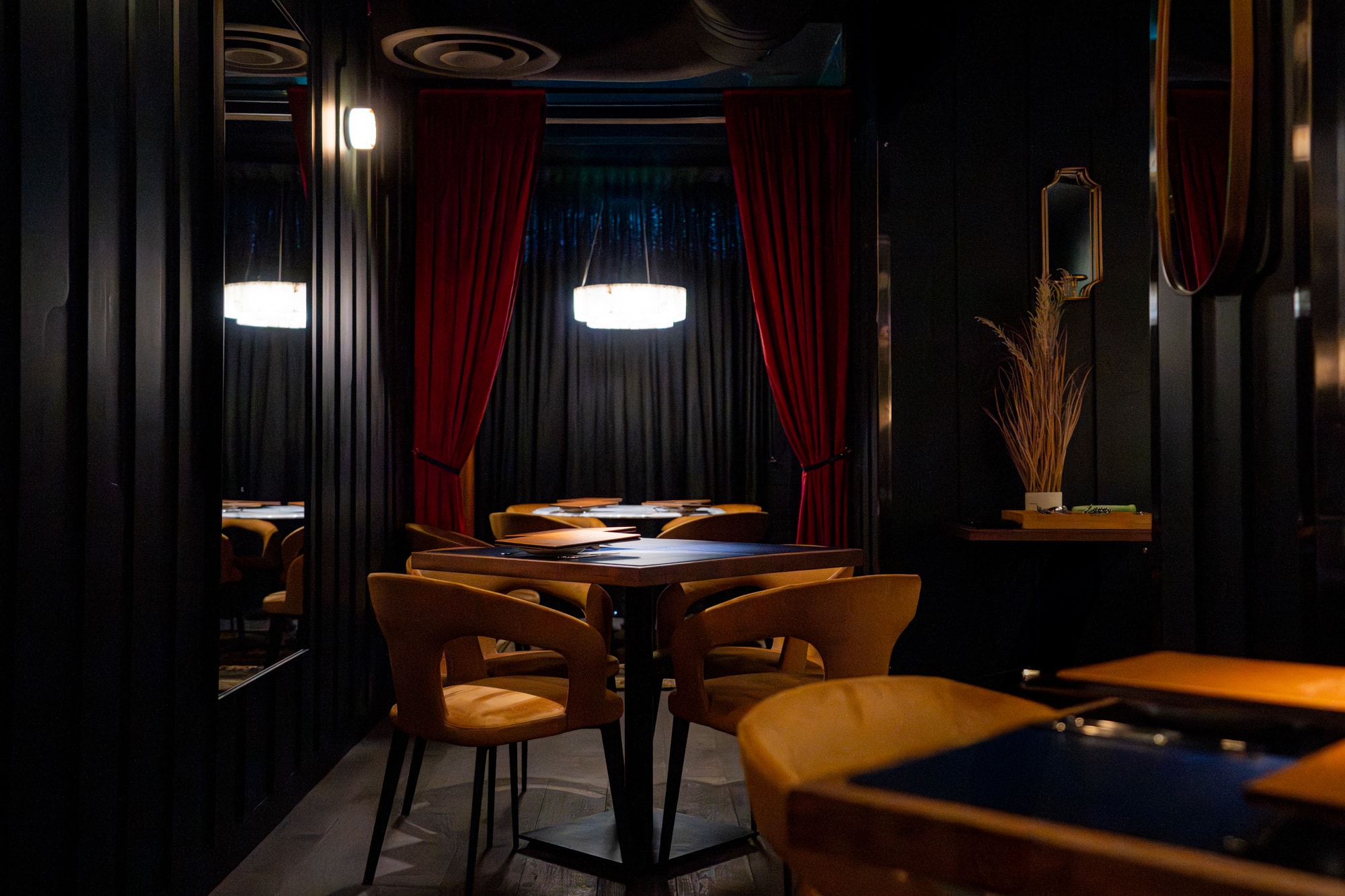 The intimate dining room at Pasta Privato — red velvet curtains and candlelight