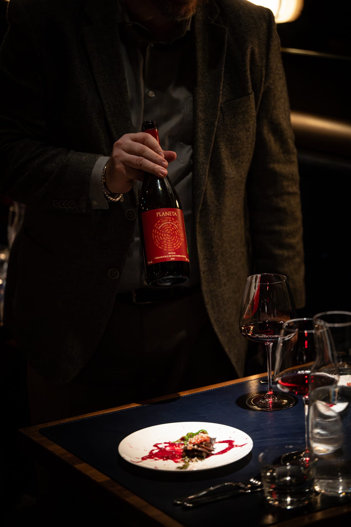 Sommelier presenting a bottle of Planeta red wine